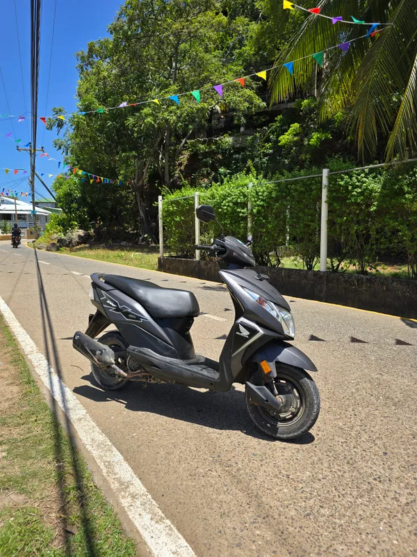 Una moto sobre asfalto con líneas pintadas en Utila