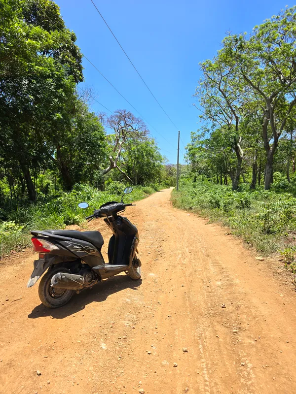Una moto sobre camino de tierra roja en Utila